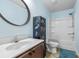 Light blue bathroom with a wood vanity and a tub/shower combo with light-colored flooring at 109 Winding Path Dr., Loris, SC 29569