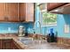 Close up on the kitchen sink featuring stainless appliances, brown cabinets, and blue walls at 109 Winding Path Dr., Loris, SC 29569