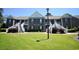 Low-angle view of a condo complex featuring multiple units with white staircases and lush lawn at 1101 Peace Pipe Pl. # 201, Myrtle Beach, SC 29579