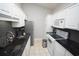 Modern kitchen featuring white cabinets, dark countertops, stainless appliances, and tile flooring at 1101 Peace Pipe Pl. # 201, Myrtle Beach, SC 29579
