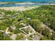 Aerial view of property highlighting wooded lot, pond, in-ground pool and water views in the distance at 12 Gloucester Pl., Pawleys Island, SC 29585