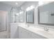 Bright bathroom with double sinks, white cabinets, and tiled shower at 12 Gloucester Pl., Pawleys Island, SC 29585