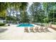 Community pool with lounge chairs and tables surrounded by trees at 12 Gloucester Pl., Pawleys Island, SC 29585