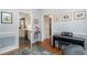 Hallway view featuring hardwood floors, a piano, and an open doorway to the kitchen at 12 Gloucester Pl., Pawleys Island, SC 29585
