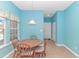 Bright breakfast nook with a wooden dining set under a pendant light and a view to the outside at 139 Chenoa Dr. # D, Murrells Inlet, SC 29576