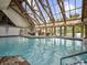 Large indoor swimming pool featuring high vaulted ceilings and abundant natural light at 14290 Ocean Hwy. # 210, Pawleys Island, SC 29585