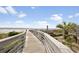 Scenic beach access featuring a wooden walkway leading to the ocean and sandy shores at 14290 Ocean Hwy. # 210, Pawleys Island, SC 29585