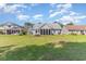 Expansive backyard with lush green grass and screened-in porches, and the back of the house at 1486 Medinah Ln., Murrells Inlet, SC 29576