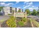 Welcoming Ocean Greens condo sign with bright flowers and building views on a sunny day at 1500 Cenith Dr. # F103, North Myrtle Beach, SC 29582