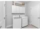 Bright laundry room features modern washer and dryer, white cabinets, and a door to another room at 1546 Villena Dr., Myrtle Beach, SC 29579