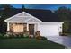 Charming single-story home with a stone facade, gray siding, well-manicured lawn, and a two-car garage at 1558 Regal Fern Way, Longs, SC 29568