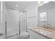 Bright bathroom featuring a glass enclosed shower, white fixtures, and a neutral granite countertop at 1611B S Ocean Blvd., Surfside Beach, SC 29575