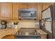 Kitchen detail of granite countertops, stainless appliances, warm cabinetry and recessed lighting at 223 Maison Dr. # C7, Myrtle Beach, SC 29572