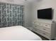 Well-furnished bedroom with a television, dresser, and blue patterned curtains at 223 S 9Th Ave. S, North Myrtle Beach, SC 29582