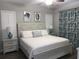 Cozy bedroom with a white bed, coastal artwork, and stylish patterned curtains at 223 S 9Th Ave. S, North Myrtle Beach, SC 29582