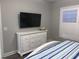 Bedroom features a white dresser with a television and shuttered windows for natural light at 223 S 9Th Ave. S, North Myrtle Beach, SC 29582