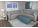Comfortable living room featuring a gray sectional, blue ottomans, side tables, and natural lighting at 223 S 9Th Ave. S, North Myrtle Beach, SC 29582