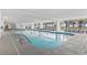 Spacious indoor pool area with lounge chairs and large windows offering views of palm trees and the outdoors at 2300 N Ocean Blvd. # 1430, Myrtle Beach, SC 29577