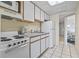 Cozy kitchen features white cabinets, essential appliances, and a view of the living area at 2300 N Ocean Blvd. # 1430, Myrtle Beach, SC 29577