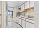 Cozy kitchen features white cabinets, essential appliances, and a view of the living area and ocean view at 2300 N Ocean Blvd. # 1430, Myrtle Beach, SC 29577