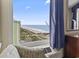 Relaxing ocean view from the condo's window with a comfy chair and partial view of the rest of the room at 2300 N Ocean Blvd. # 1430, Myrtle Beach, SC 29577
