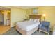 Comfortable bedroom with a plush armchair, seascape art, and a convenient doorway to the bathroom area at 2301 S Ocean Blvd. # 130, Myrtle Beach, SC 29577