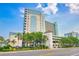 Beautiful exterior view of the Compass Cove Resort with palm trees and a bright blue sky at 2301 S Ocean Blvd. # 130, Myrtle Beach, SC 29577
