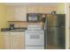 This is a kitchenette featuring a microwave, stove, sink, and refrigerator, perfect for preparing small meals at 2301 S Ocean Blvd. # 130, Myrtle Beach, SC 29577