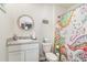 Bright bathroom with a round mirror, single vanity, and a colorful shower curtain at 231 Jeff Waters Circle, Longs, SC 29568