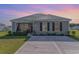 Charming single-story home featuring a well-manicured lawn, neutral siding, and a cozy front porch area at 231 Jeff Waters Circle, Longs, SC 29568