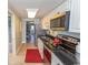 Galley kitchen with stainless steel appliances, black countertops, and ample cabinet space at 2406 N Ocean Blvd. # 803, Myrtle Beach, SC 29577
