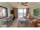 Sunlit living room featuring a ceiling fan, tile floors, glass table, and ocean views from the balcony at 2406 N Ocean Blvd. # 803, Myrtle Beach, SC 29577