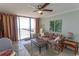 Inviting living room with a ceiling fan, tile flooring, balcony access, and tropical-themed accents at 2406 N Ocean Blvd. # 803, Myrtle Beach, SC 29577