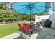 Outdoor patio area with a black grill, red patio furniture, and an umbrella, set against a lush green lawn at 255 Tibton Circle, Myrtle Beach, SC 29588
