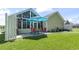 Back patio featuring a dining set with an umbrella next to the screened-in porch and grassy yard at 255 Tibton Circle, Myrtle Beach, SC 29588