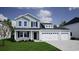 Two-story home with light-blue and grey siding, a black front door, and a three car attached garage at 269 Mayflower Dr., Calabash, NC 28467