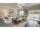 Bright living room with a ceiling fan, hardwood floors, a large sofa, and sliding glass doors at 269 Mayflower Dr., Calabash, NC 28467