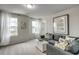Living room has large windows, a gray couch with decorative pillows, and plush carpet at 269 Mayflower Dr., Calabash, NC 28467