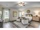 Spacious main bedroom with vaulted ceilings, two chairs, a ceiling fan, and hardwood floors at 269 Mayflower Dr., Calabash, NC 28467