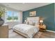 Stylish bedroom featuring an accent wall, a plush bed, and scenic views from a large window at 2884 Riverboat Way, Conway, SC 29526