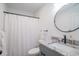 Stylish bathroom features a granite countertop, a round mirror, and updated fixtures at 294 Field Loop Rd., Georgetown, SC 29440
