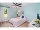 This cozy bedroom features light blue walls, a ceiling fan, and a window with natural light at 294 Field Loop Rd., Georgetown, SC 29440