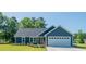 Beautiful single-story home with a blue exterior, well-maintained lawn, and a two-car garage at 294 Field Loop Rd., Georgetown, SC 29440