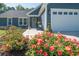 Close-up of a home's front exterior, showcasing flowers and the well-lit two-car garage at 294 Field Loop Rd., Georgetown, SC 29440