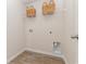 Efficient laundry room space with wood-look flooring, overhead storage, and utility connections at 296 Clear Lake Dr., Conway, SC 29526