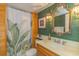 Bathroom features tropical themed wallpaper, a vanity with ornate mirror and unique lighting fixtures, creating a stylish oasis at 311 71St Ave. N # 5A, Myrtle Beach, SC 29572