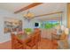 A dining area with a wooden table, chandelier, and a painting, leading to the living area and a balcony view at 311 71St Ave. N # 5A, Myrtle Beach, SC 29572