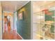 Hallway view showcasing tiled floors, textured green walls, and a glass display cabinet at 311 71St Ave. N # 5A, Myrtle Beach, SC 29572