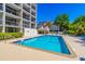 Bright swimming pool area with a sun deck and view of the building under a clear blue sky at 311 71St Ave. N # 5A, Myrtle Beach, SC 29572
