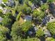 Lush, private backyard with mature trees, a wooden fence, a pool and driveway in an overhead aerial shot at 314 Trace Run, Myrtle Beach, SC 29588